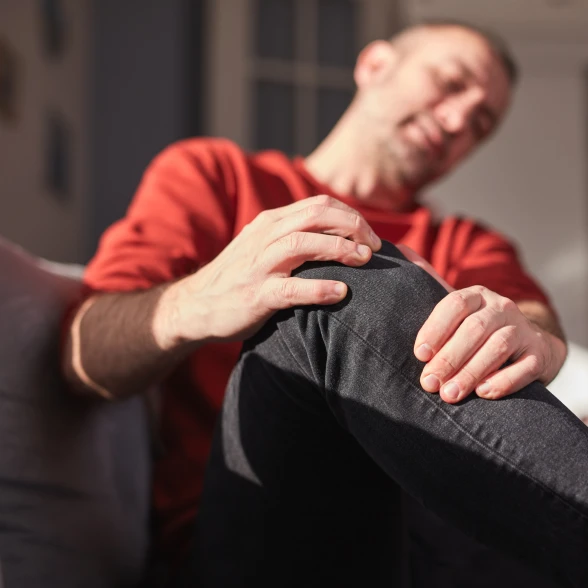 Douleurs articulaires au genou Un homme se touche le genou qui lui fait mal
