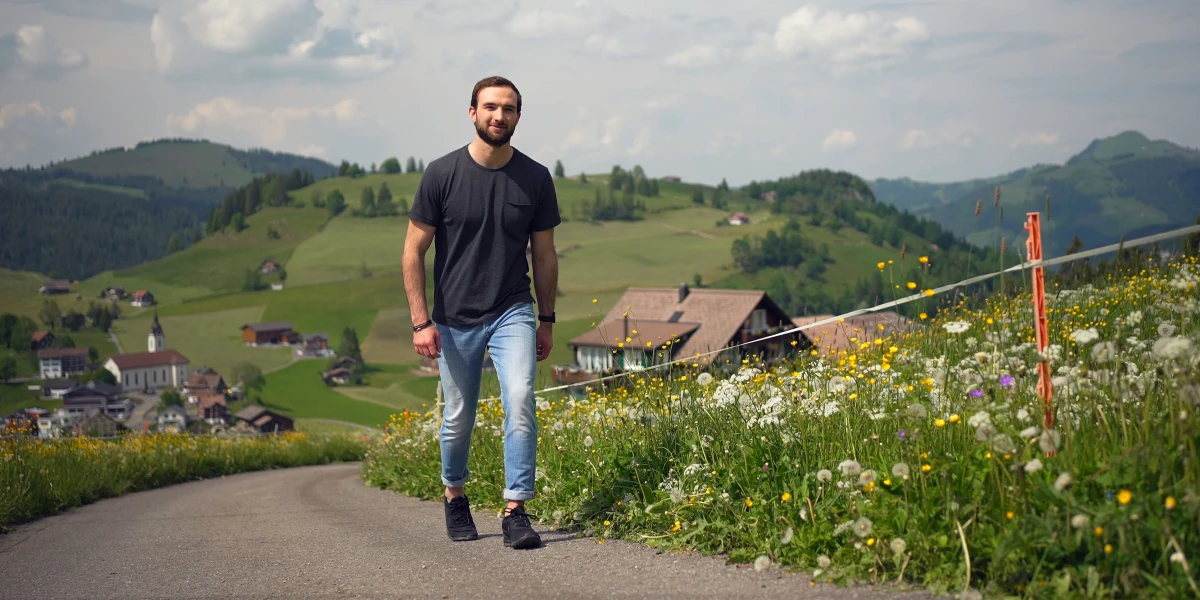 Un homme remonte un chemin de campagne.