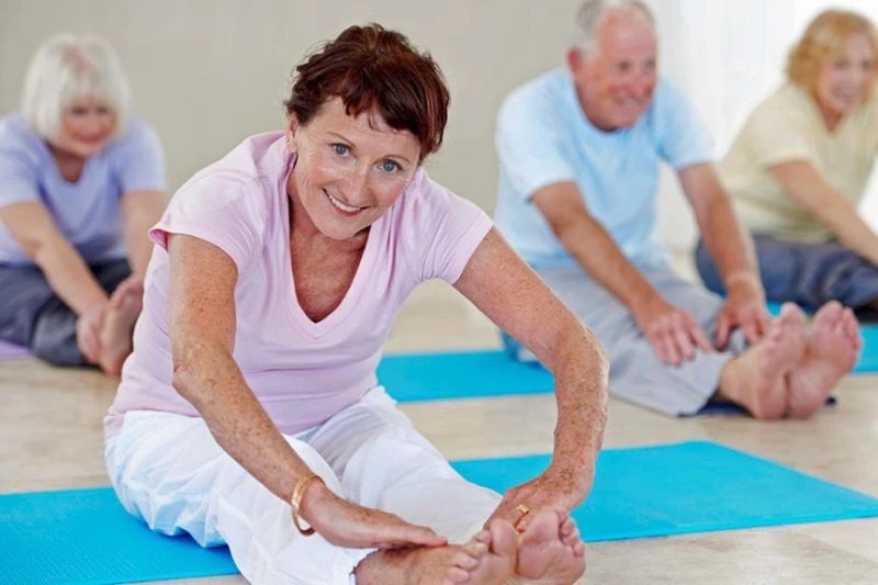 Active Backademy Personnes en position d'étirement, assises sur un tapis de gymnastique