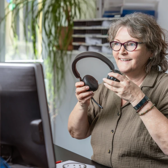 Conseil par téléphone Une conseillère met son casque téléphonique
